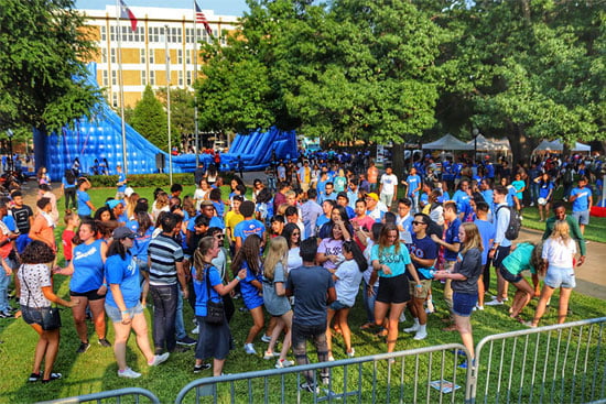 Large amount of students at Convocation Afterparty with inflatable rides and food stands outside