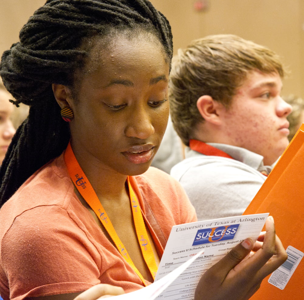 Student reading a paper document.