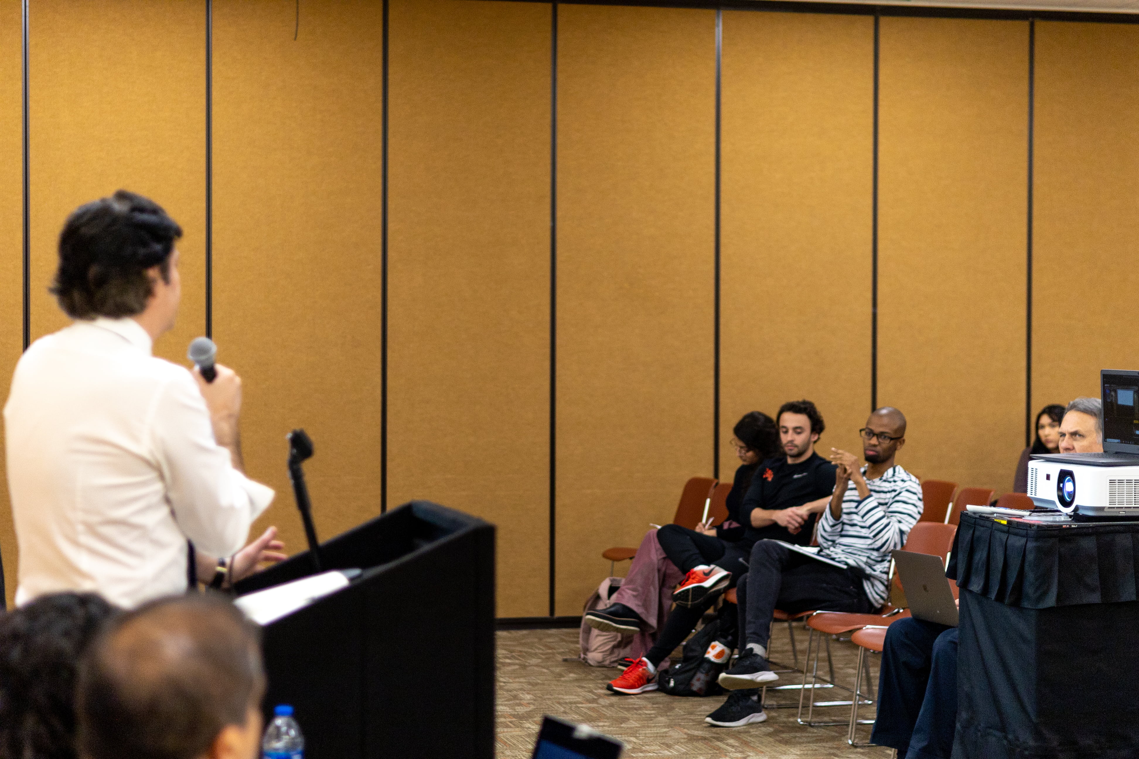 Photo of a person talking to a room full of people